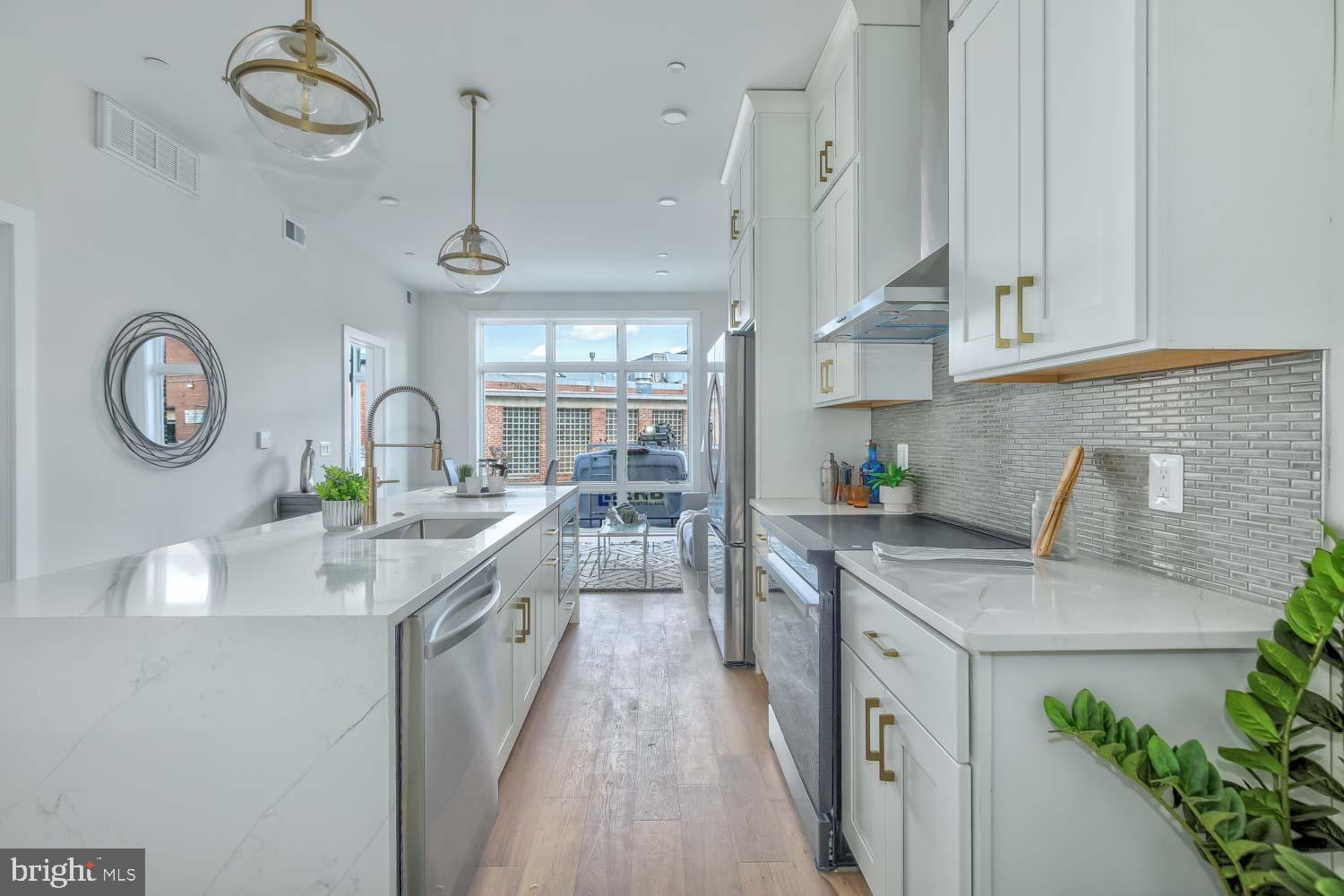 4347 Harrison Street Northwest, Unit 4 Washington, DC 20015 - Photo 4 of 16 a kitchen with stainless steel appliances granite countertop a sink a stove top oven a clock and cabinets