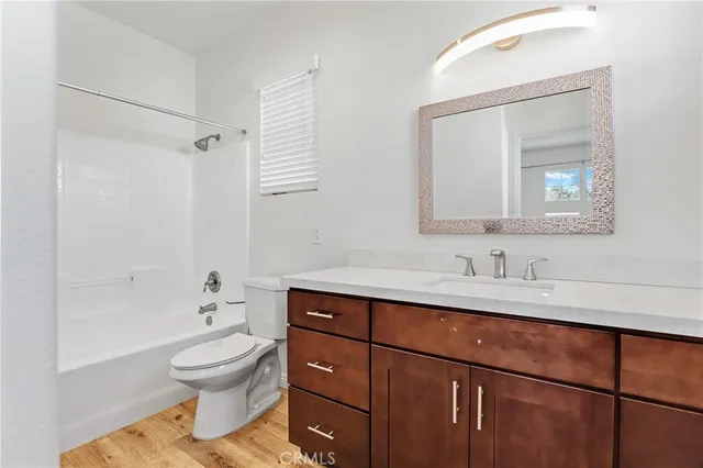 a bathroom with a toilet sink a mirror and vanity
