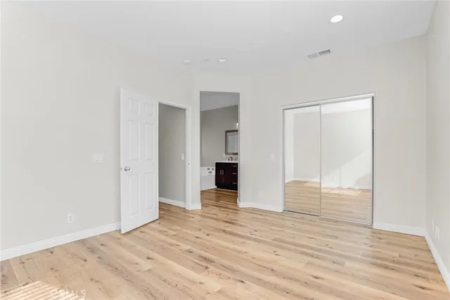 a view of a big room with wooden floor and entryway