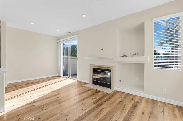 a view of empty room with kitchen and window