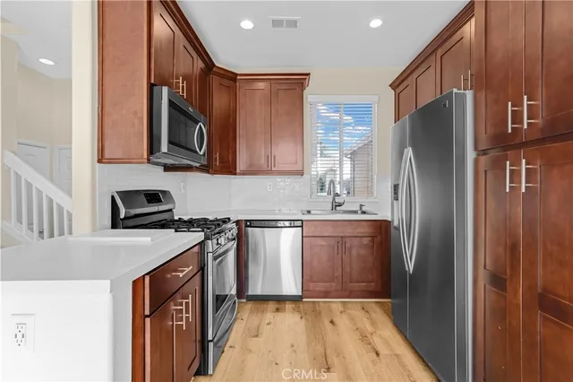 a kitchen with stainless steel appliances granite countertop a refrigerator stove and sink