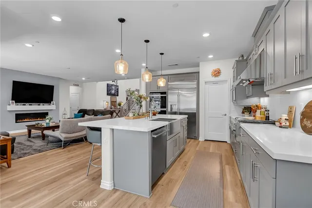 a kitchen with stainless steel appliances kitchen island granite countertop a sink a stove and a refrigerator