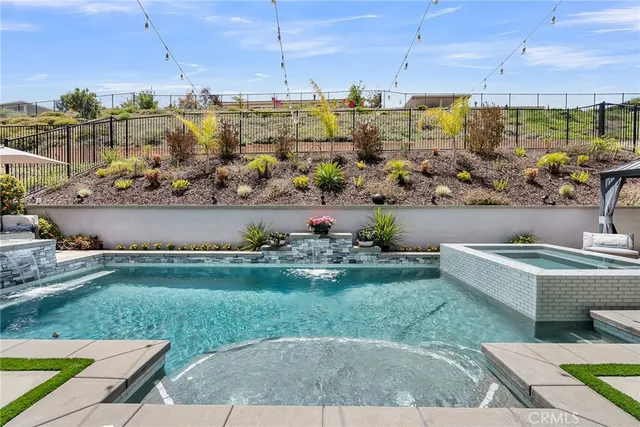 a front view of a house with swimming pool and furniture