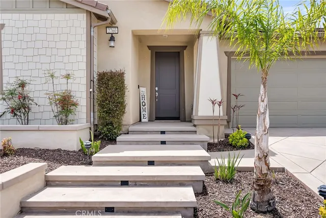 a view of a house with potted plants and a fountain