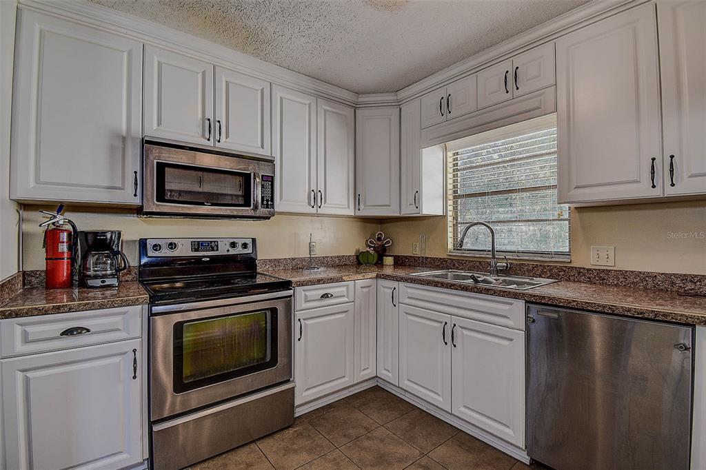 11425 Sun Road Dade City, FL 33525 - Photo 12 of 41 a kitchen with granite countertop cabinets stainless steel appliances and a sink
