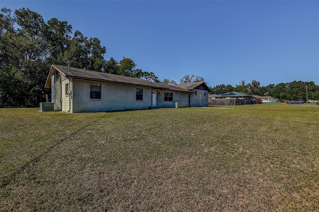 11425 Sun Road Dade City, FL 33525 - Photo 36 of 41 a view of a house with a yard and a large tree