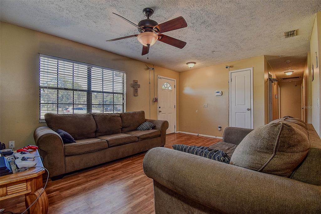 11425 Sun Road Dade City, FL 33525 - Photo 8 of 41 a living room with furniture ceiling fan and a window