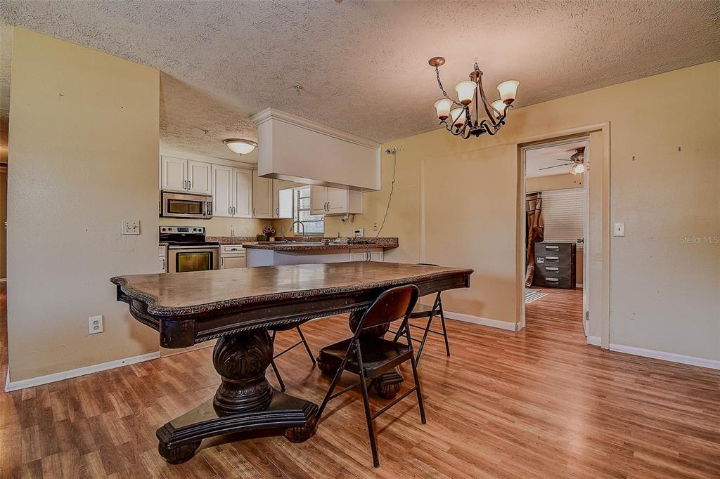 11425 Sun Road Dade City, FL 33525 - Photo 10 of 41 a view of a dining room with furniture and wooden floor