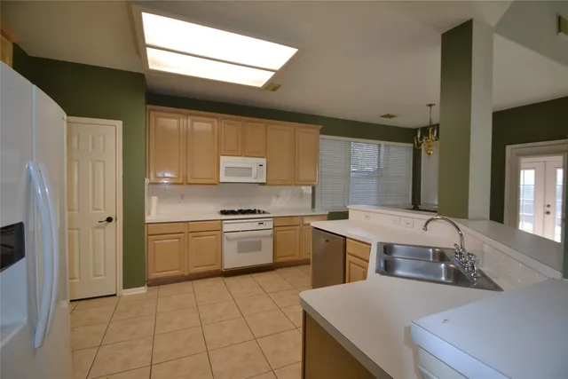 a kitchen with stainless steel appliances granite countertop a sink a stove top oven and cabinets