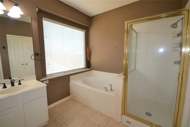 an empty room with a chandelier fan and windows
