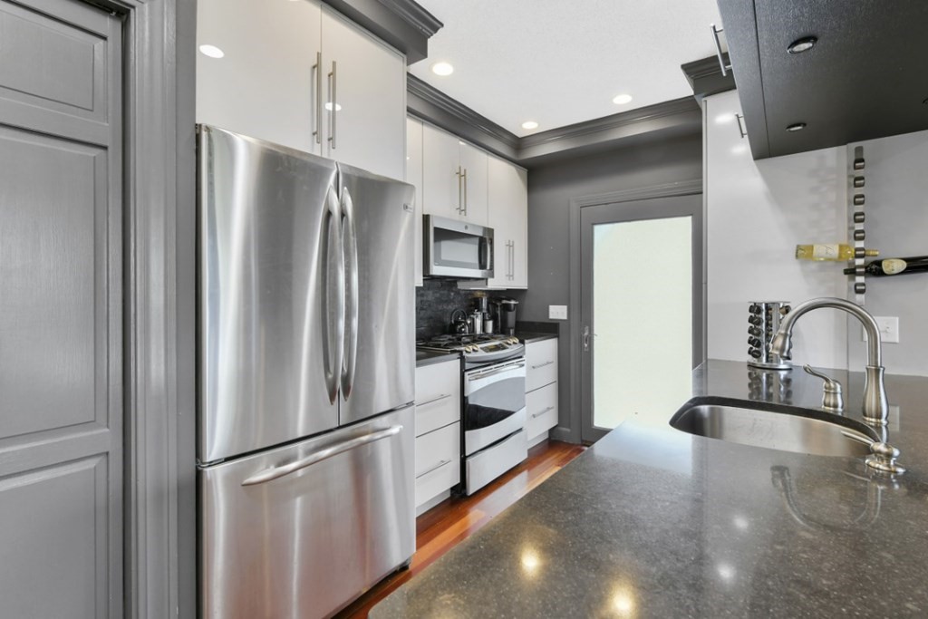 7 Cummings Road, Unit 7 Boston, MA 02135 - Photo 4 of 19 a kitchen with stainless steel appliances a refrigerator sink and white cabinets