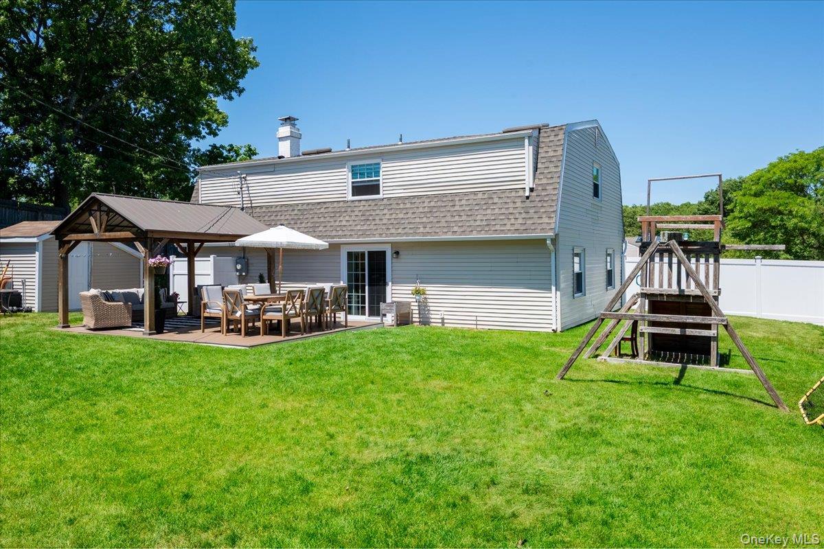 10 Rutgers Road Farmingville, NY 11738 - Photo 23 of 27 a view of a house with backyard porch and sitting area
