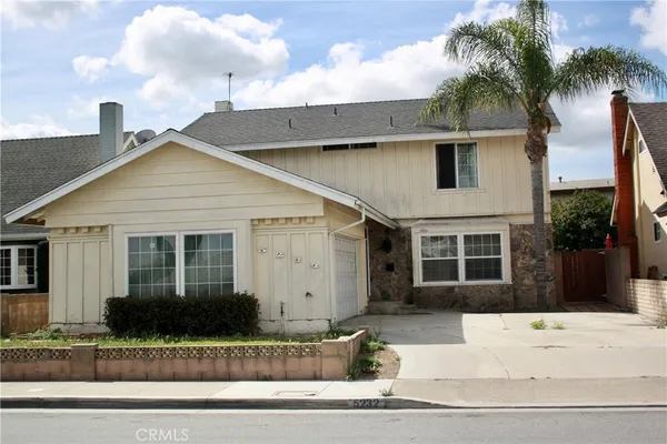 a view of a house with a yard and potted plants