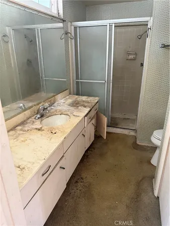 a bathroom with a granite countertop sink a toilet and shower