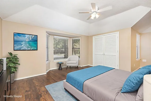 a bedroom with a large bed couch and a window
