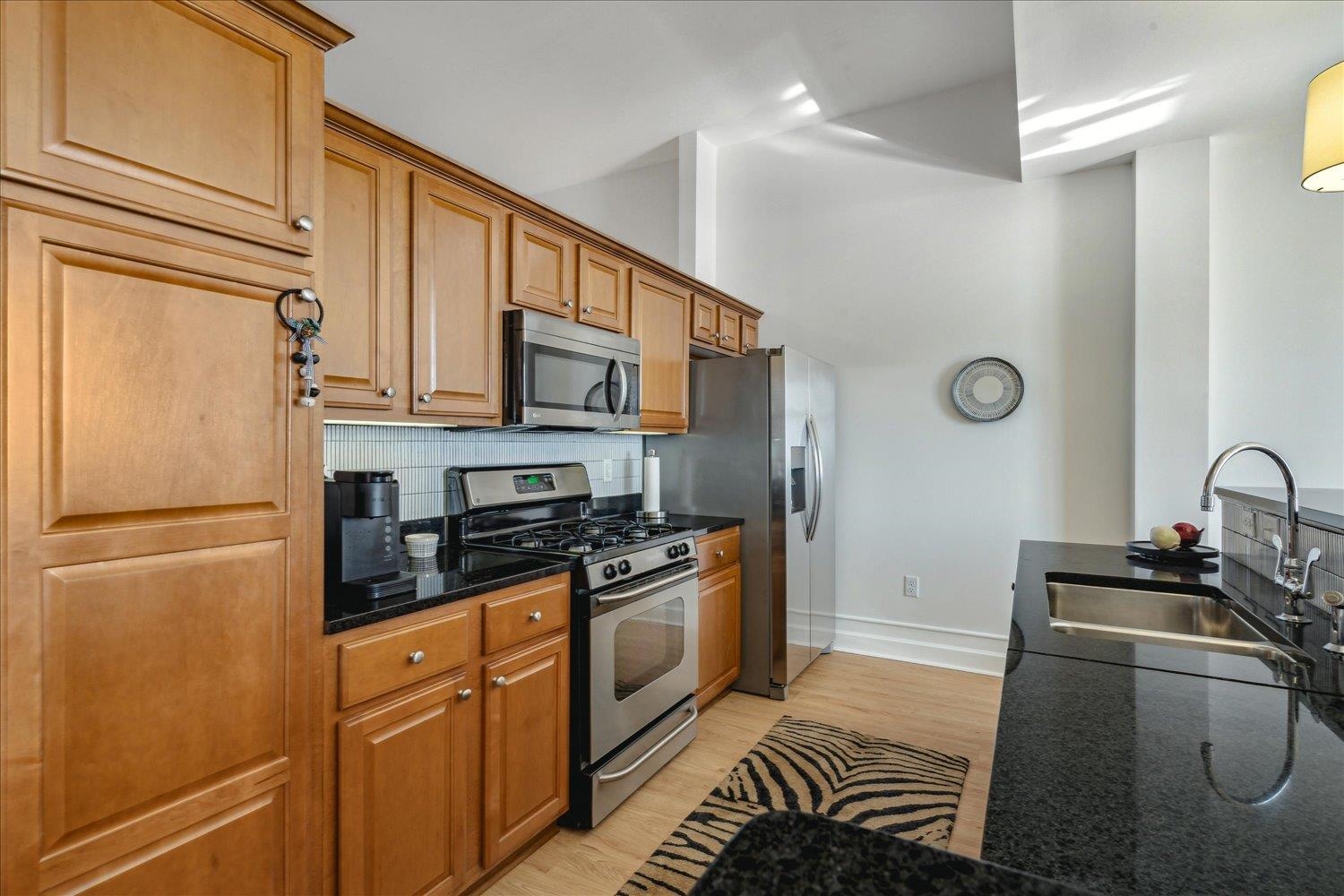 648 Riverside Drive, Unit 411 Memphis, TN 38103 - Photo 11 of 32 Kitchen featuring decorative backsplash, appliances with stainless steel finishes, light hardwood / wood-style floors, and sink