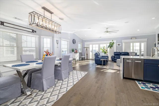 a kitchen with stainless steel appliances granite countertop a table chairs and a refrigerator