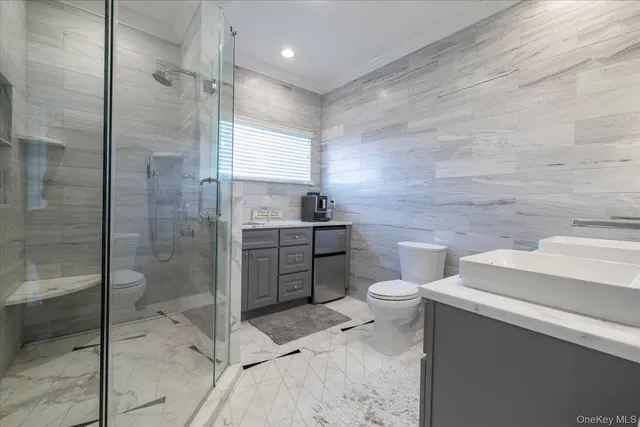a bathroom with a granite countertop sink a toilet and shower