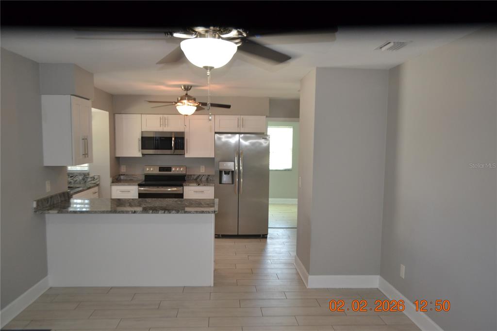 6204 West Knights Griffin Road Plant City, FL 33565 - Photo 5 of 19 a kitchen with stainless steel appliances a refrigerator a stove a sink and dishwasher