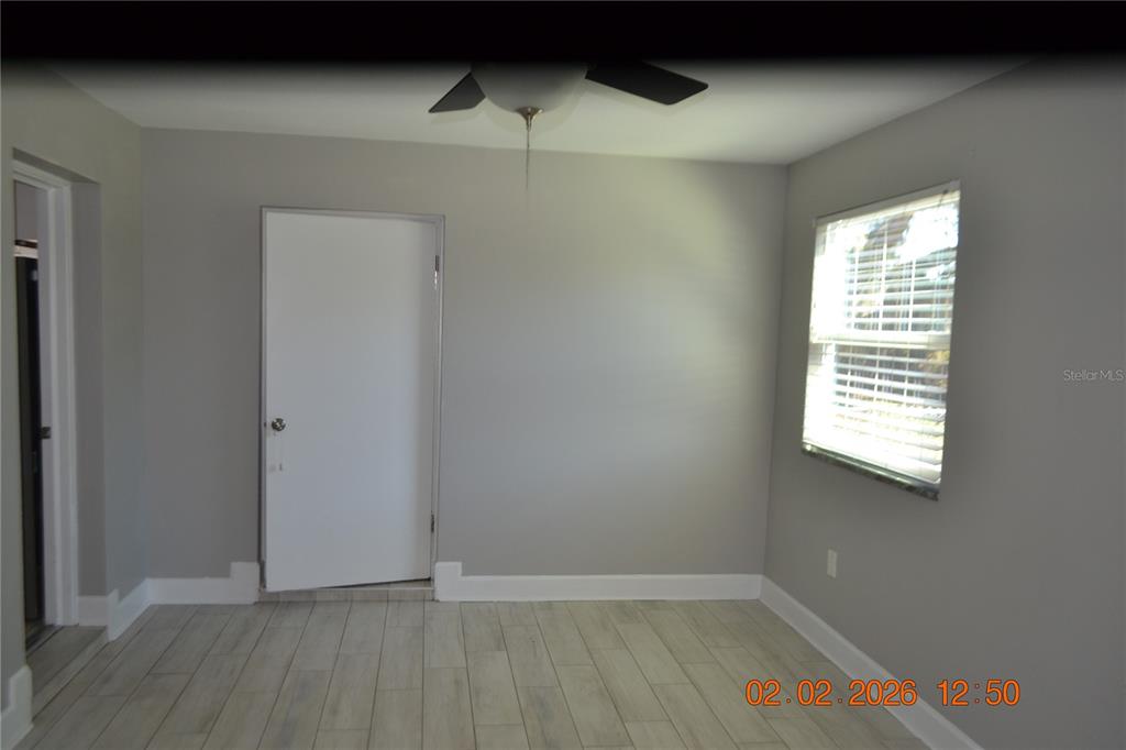 6204 West Knights Griffin Road Plant City, FL 33565 - Photo 7 of 19 a view of an empty room with wooden floor and a window