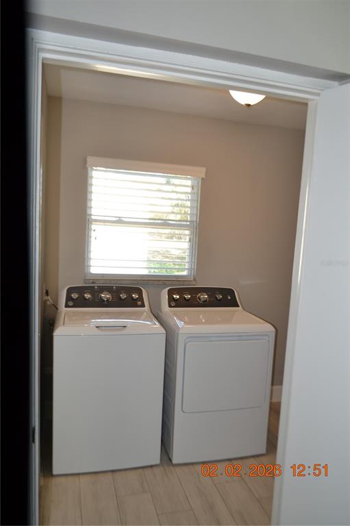 6204 West Knights Griffin Road Plant City, FL 33565 - Photo 8 of 19 a view of washer and dryer with kitchen in the background
