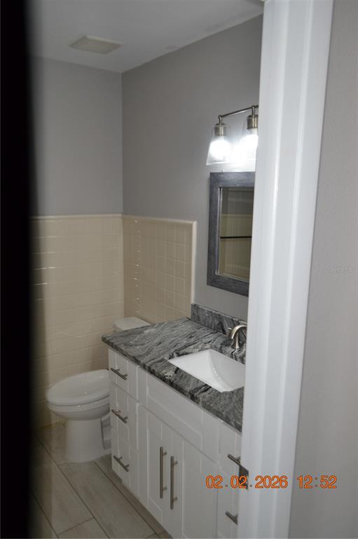 6204 West Knights Griffin Road Plant City, FL 33565 - Photo 9 of 19 a bathroom with a granite countertop sink and a toilet