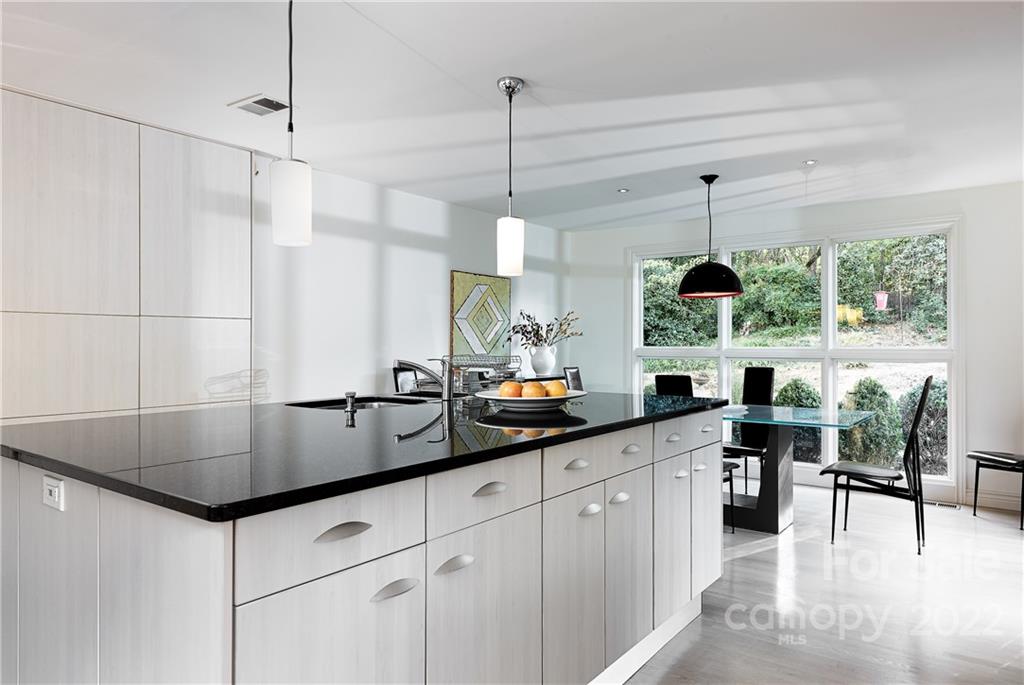 3234 Mountainbrook Road Charlotte, NC 28210 - Photo 17 of 48 a kitchen with stainless steel appliances granite countertop a sink a stove and a wooden floors