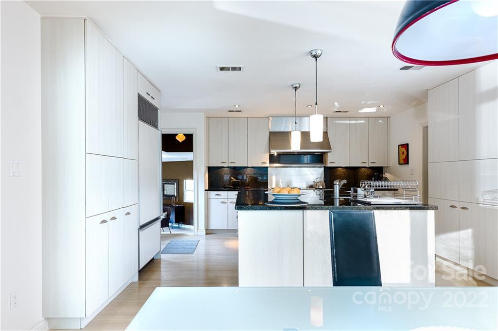 3234 Mountainbrook Road Charlotte, NC 28210 - Photo 18 of 48 a kitchen with stainless steel appliances granite countertop a refrigerator a sink dishwasher a stove and white cabinets with wooden floor