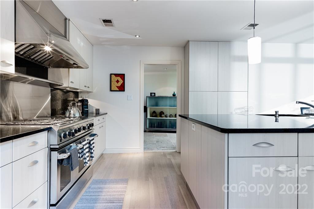 3234 Mountainbrook Road Charlotte, NC 28210 - Photo 20 of 48 a kitchen with kitchen island a sink stainless steel appliances and cabinets