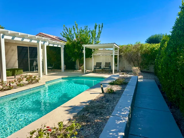 a view of a patio with a table and chairs under an umbrella