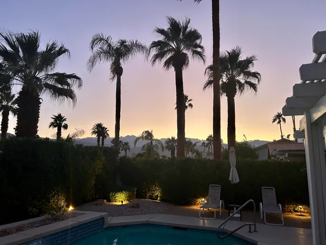 a front view of a house with palm trees