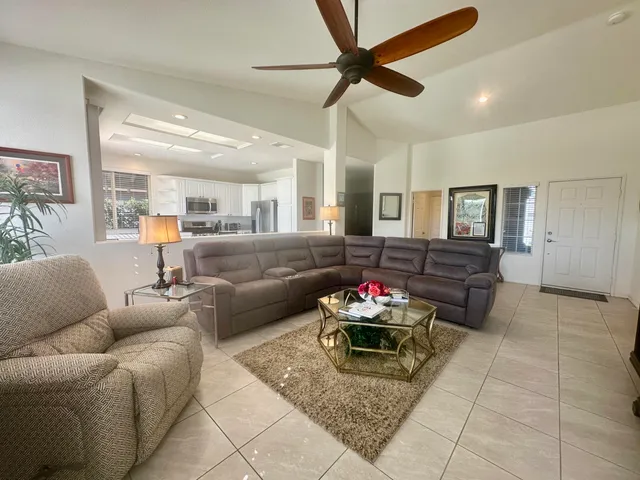 a living room with furniture ceiling fan and a window
