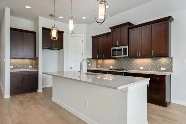 a kitchen with stainless steel appliances granite countertop a sink a stove and a refrigerator