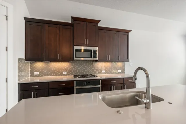 a kitchen with granite countertop a sink and a stove top oven