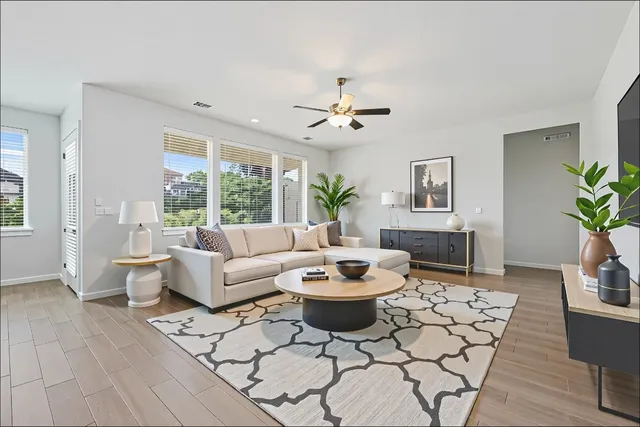 a large kitchen with stainless steel appliances a large window a oven and a wooden floors