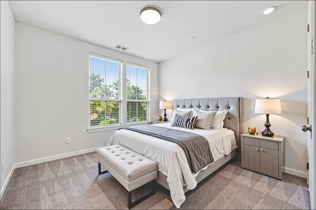 a bedroom with a bed and a large window