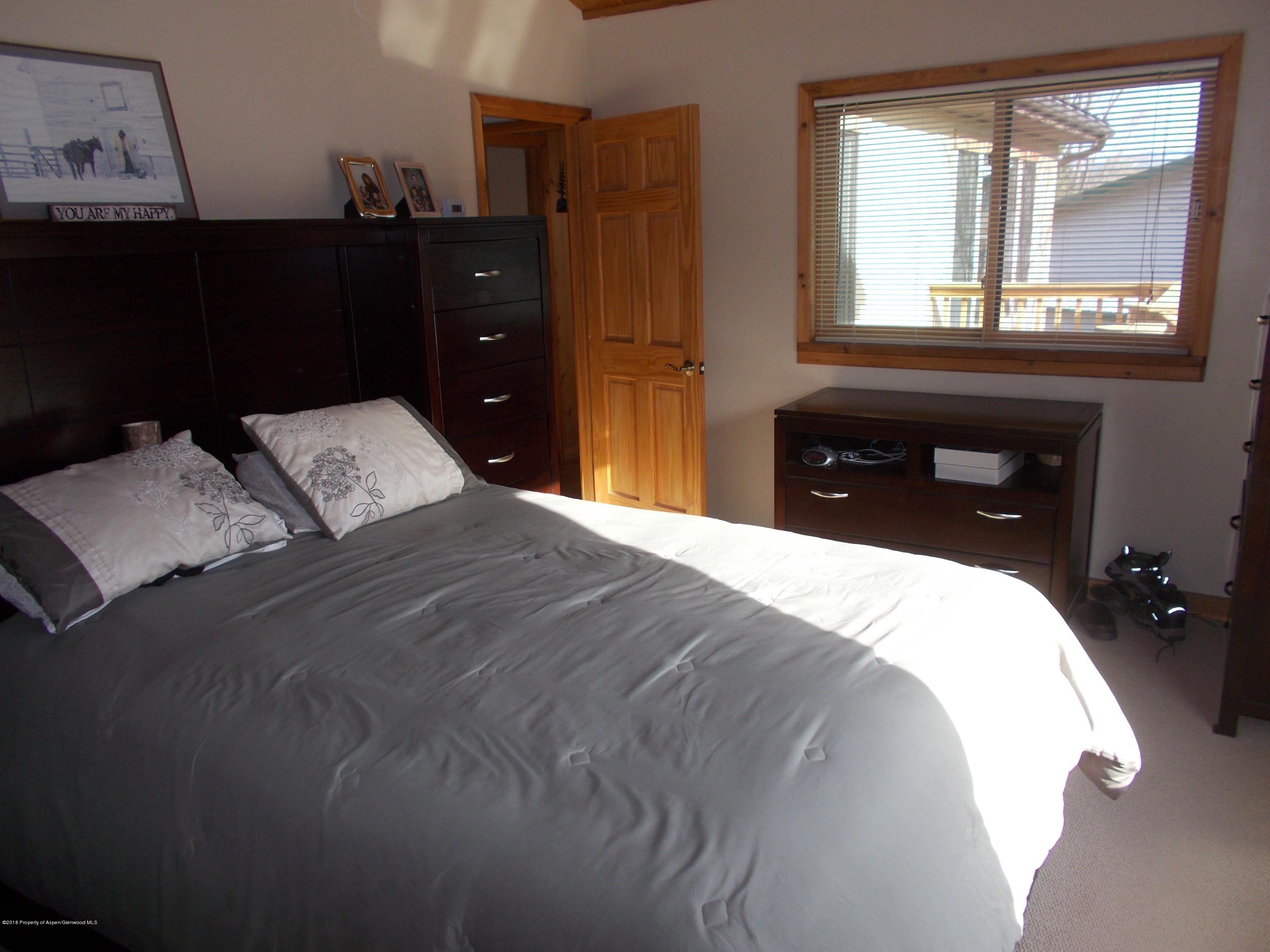 712 Buckeye Court Rifle, CO 81650 - Photo 13 of 22 a bedroom with a bed and a dresser