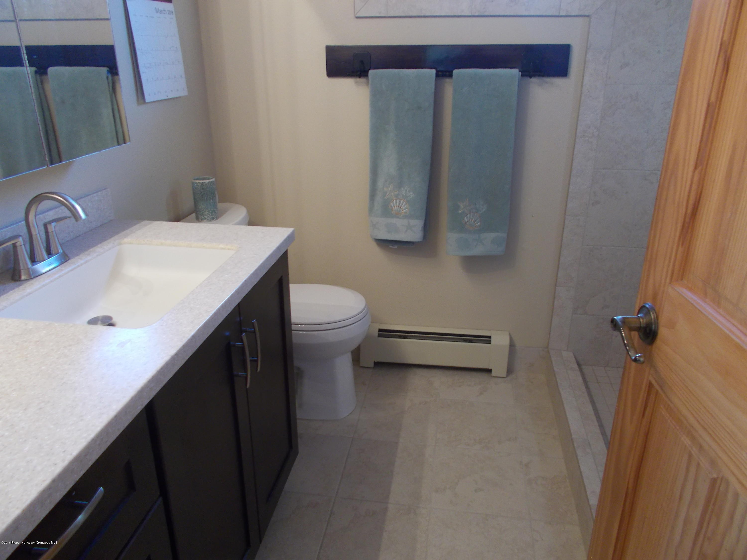 712 Buckeye Court Rifle, CO 81650 - Photo 17 of 22 a bathroom with a sink a toilet and mirror