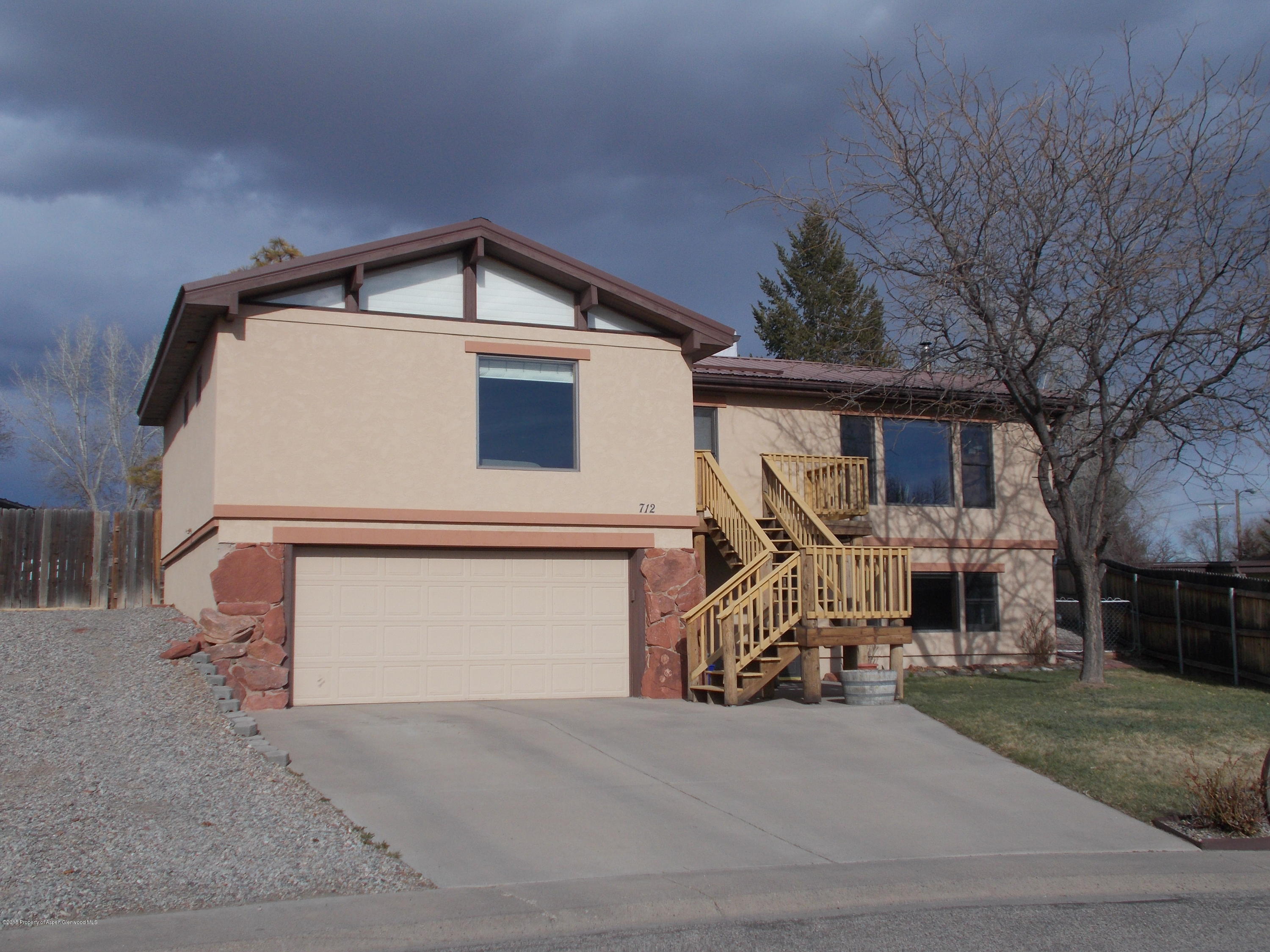 712 Buckeye Court Rifle, CO 81650 - Photo 3 of 22 a front view of a house with a yard and garage