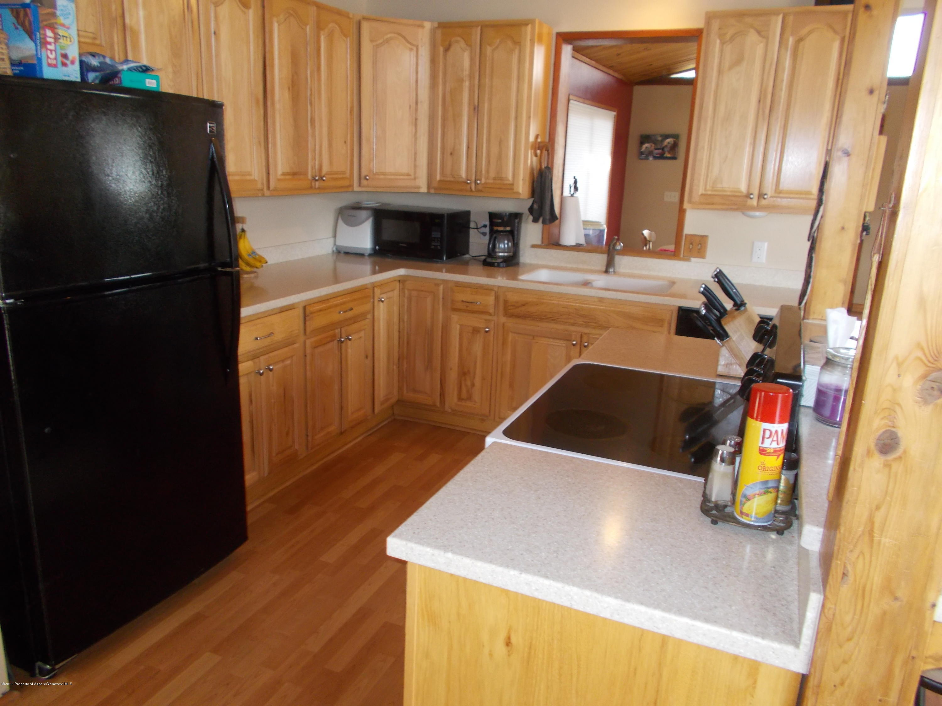 712 Buckeye Court Rifle, CO 81650 - Photo 8 of 22 a kitchen with stainless steel appliances granite countertop a sink a stove and a refrigerator
