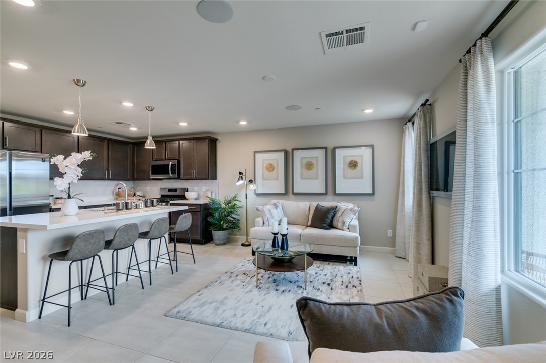 653 Pickled Pepper Place Henderson, NV 89011 - Photo 34 of 35 An open floorplan seamlessly connects the kitchen with a convenient breakfast bar to the inviting living area.