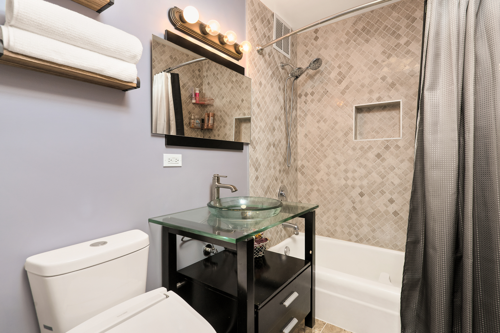 655 West Irving Park Road, Unit 705 Chicago, IL 60613 - Photo 8 of 9 a bathroom with a toilet a sink and a mirror