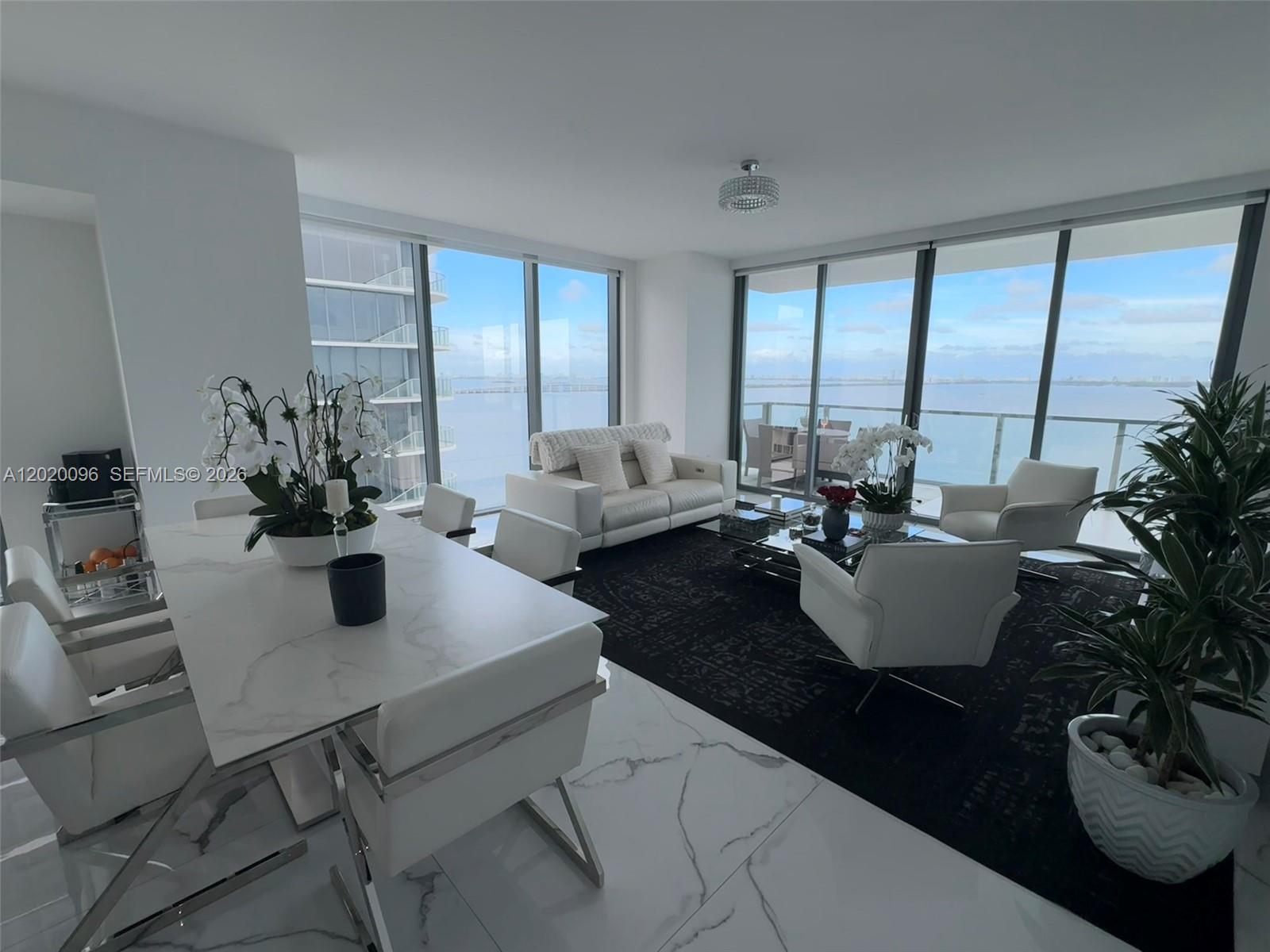788 Northeast 23rd Street, Unit 1202 Miami, FL 33137 - Photo 3 of 64 a living room with furniture potted plant and a large window