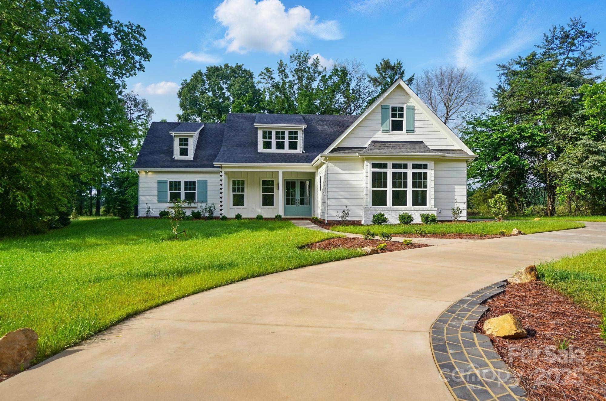 a front view of a house with a yard and potted plants