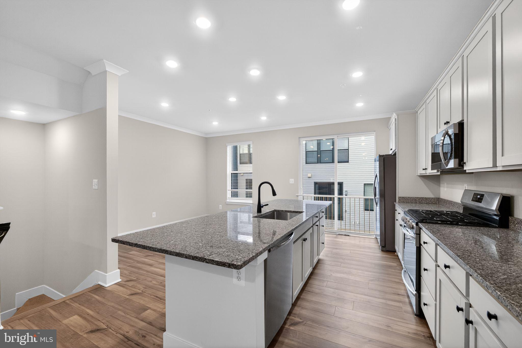 1505 Roland Heights Avenue Baltimore, MD 21211 - Photo 14 of 36 a large kitchen with stainless steel appliances granite countertop a lot of counter space and wooden floor