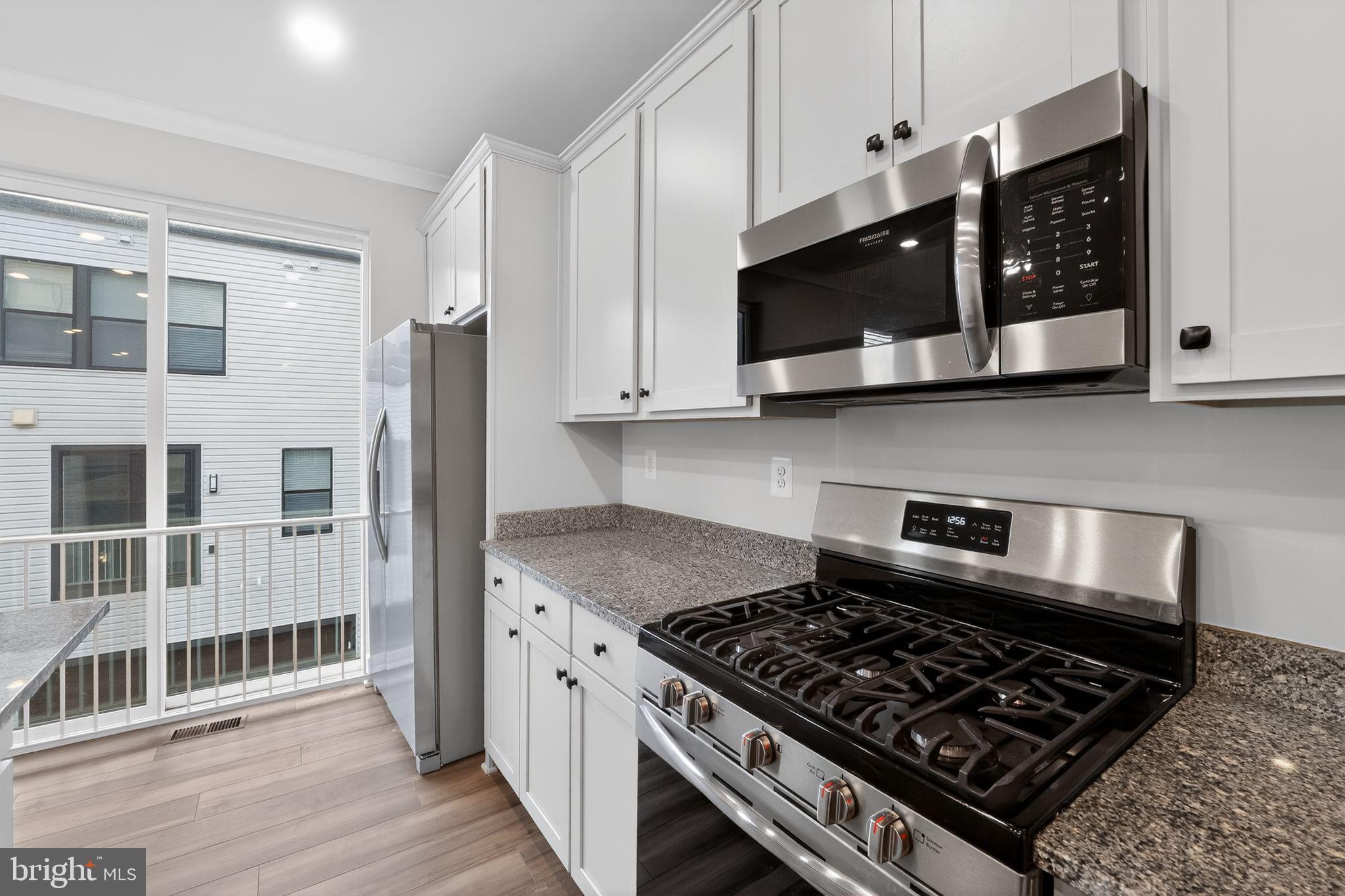 1505 Roland Heights Avenue Baltimore, MD 21211 - Photo 15 of 36 a kitchen with stainless steel appliances granite countertop a stove and a microwave