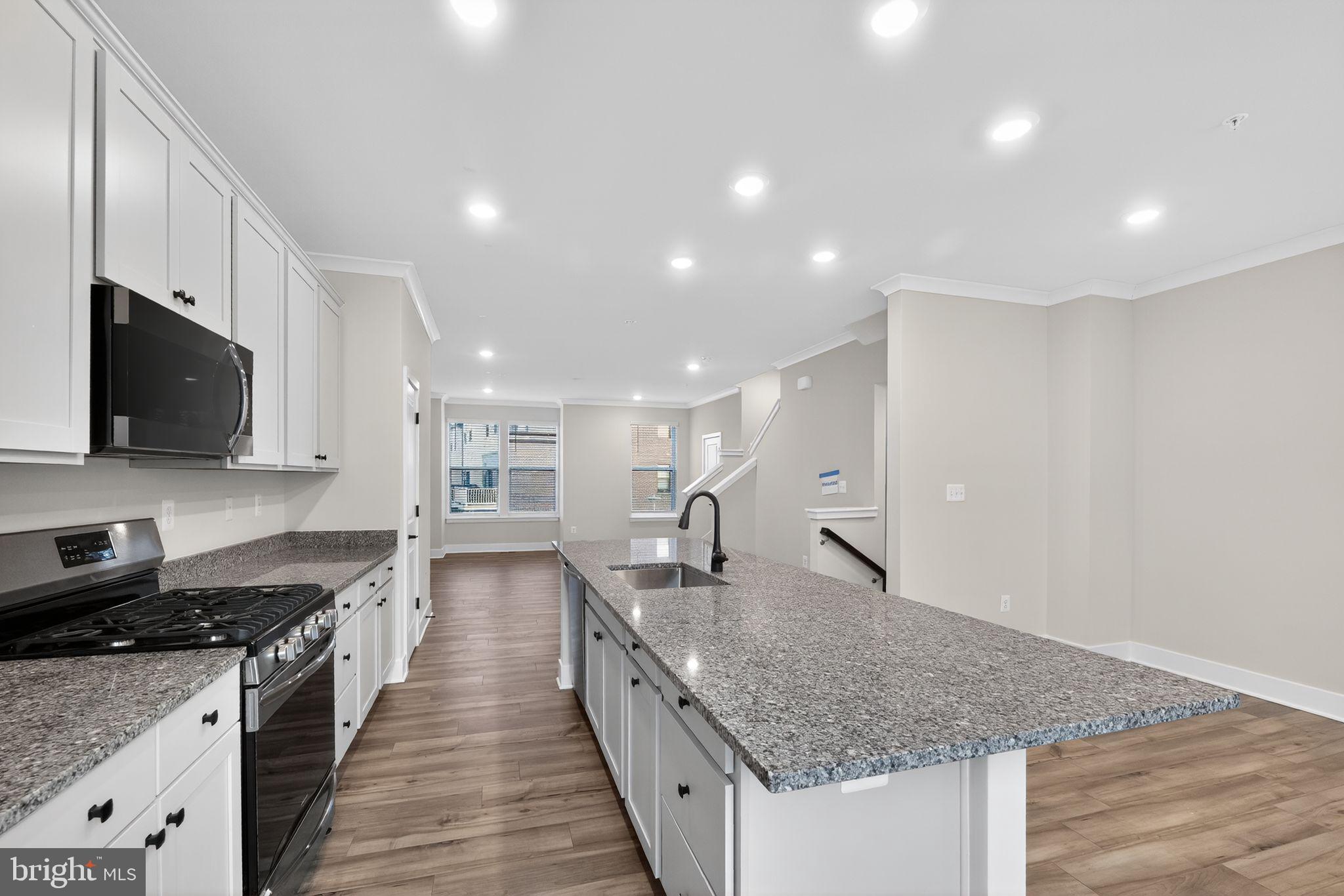 1505 Roland Heights Avenue Baltimore, MD 21211 - Photo 16 of 36 a large kitchen with stainless steel appliances granite countertop a lot of counter space and wooden floor