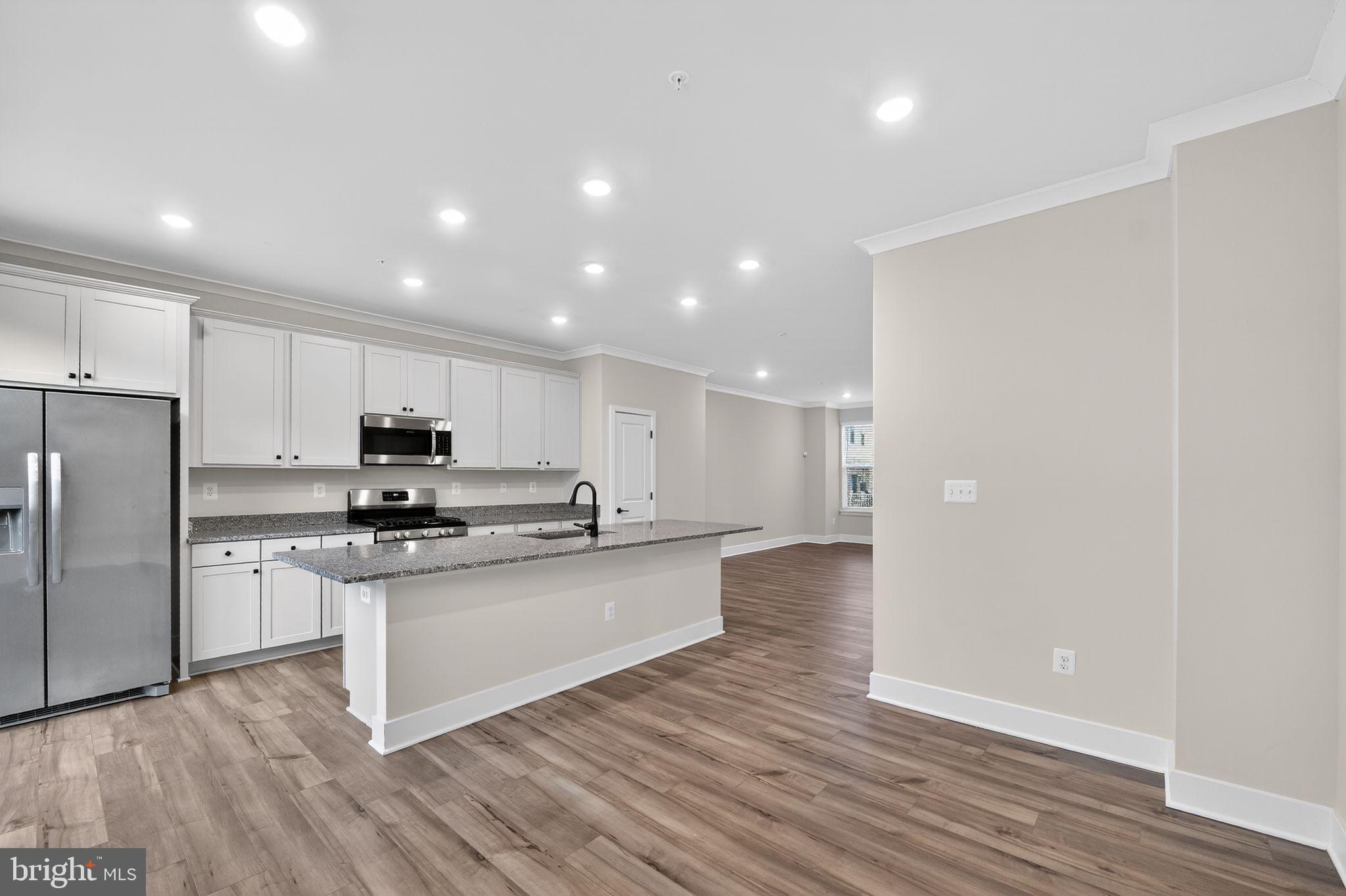 1505 Roland Heights Avenue Baltimore, MD 21211 - Photo 18 of 36 a kitchen with stainless steel appliances a refrigerator and a stove top oven