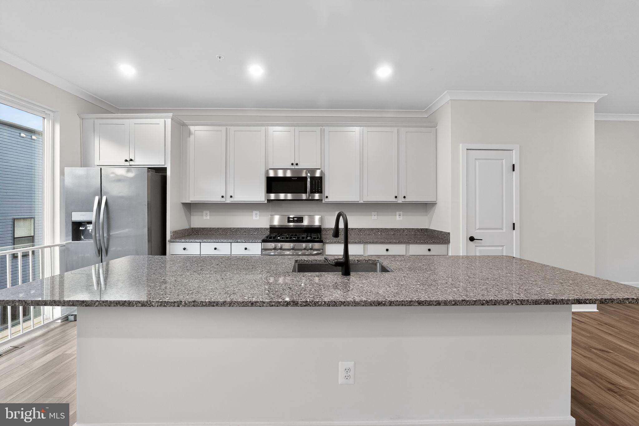 1505 Roland Heights Avenue Baltimore, MD 21211 - Photo 19 of 36 a kitchen with stainless steel appliances granite countertop a sink a refrigerator and a granite counter tops