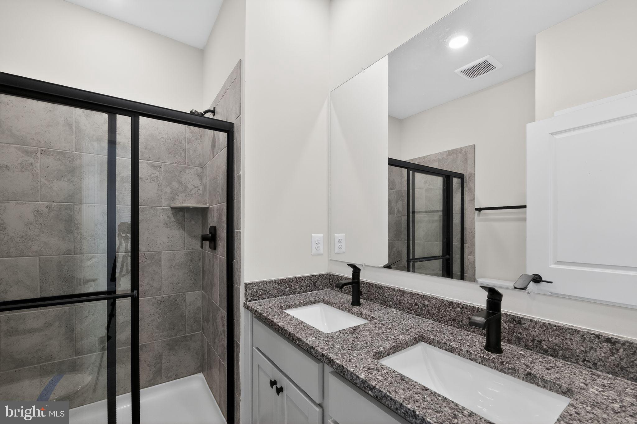 1505 Roland Heights Avenue Baltimore, MD 21211 - Photo 29 of 36 a bathroom with a granite countertop sink and a mirror